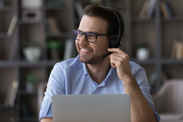 Positive smiling millennial male wear headphones with mic call center worker telephonist operator...