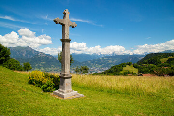 Fototapeta na wymiar Cross in meadow in French Alpes