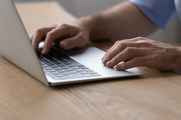 Working on laptop. Close up of millennial male hands typing text on modern notebook computer keyboard. Young man user browse web search information online prepare electronic report check email on pc