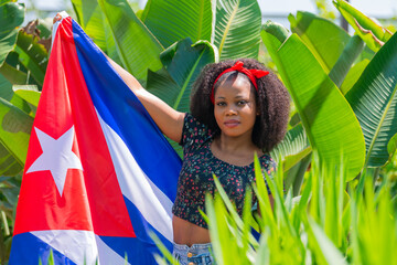 Afro woman with a Cuban flag outdoors
