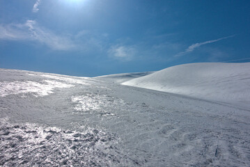 Smooth snowy hills glittering in the sunlight