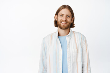 Portrait of handsome blond guy with beard, smiling hipster man in white shirt, looking happy and...