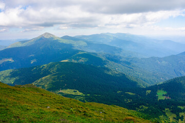 Naklejka premium carpathian mountain landscape in summer. hoverla peak and chornohora ridge in the distance. cloudy afternoon weather