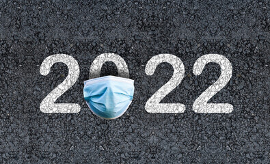 Year 2022 on asphalt road with Surgical Face Mask. happy new year 2022