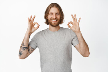 Image of handsome blond bearded guy, man showing OK okay sign in approval, nod to praise,...