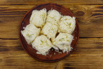 Traditional Turkish dessert Pismaniye with pistachios on wooden table. Top view