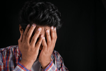 Close up of sad man covering face with hand.