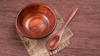 Empty wooden bowl and wooden spoon isolated with copy space.