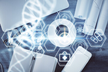 DNA hologram drawings over computer on the desktop background. Top view. Multi exposure. Concept medical education.