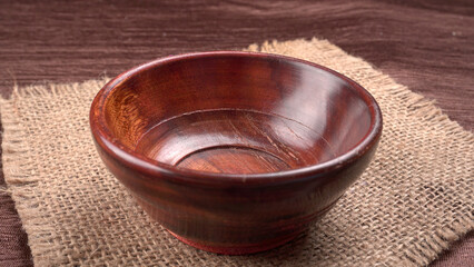 Empty wooden bowl and wooden spoon isolated with copy space.