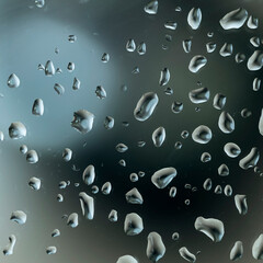 Abstract image of water droplets on glass surface reflecting with multicolored background.