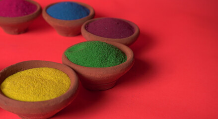 Diwali Festival showing Colourful rangoli in bowls,clay lamp or diya on background