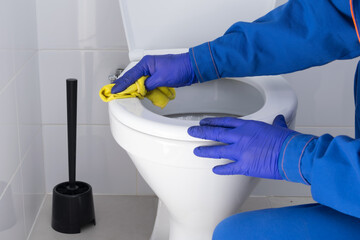 close-up of cleaning the toilet with a rag with disinfectant