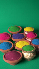 Diwali Festival showing Colourful rangoli in bowls,clay lamp or diya on background