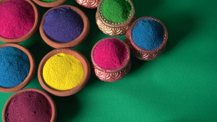 Diwali Festival showing Colourful rangoli in bowls,clay lamp or diya on background