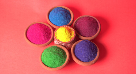 Diwali Festival showing Colourful rangoli in bowls,clay lamp or diya on background