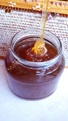 jar of bee honey on the background of the frame with honeycombs