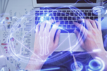 Double exposure of man's hands typing over computer keyboard and science theme hologram drawing. Top view. Education concept.