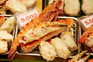 Steamed snow crab on display with price tags in a traditional market
