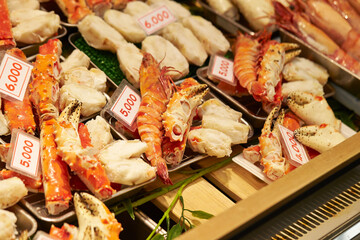 Steamed snow crab on display with price tags in a traditional market