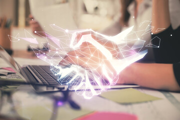 Double exposure of woman hands typing on computer and handshake drawing. Partnership concept.