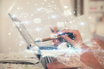 Double exposure of woman hands typing on computer and flying envelop drawing. E-Mail concept.