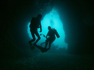 Divers exploding cave underwater. Andaman sea, Thailand.