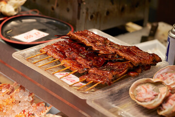 Grilled eel skewers displayed in a traditional market