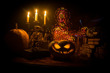 Halloween still-life background with different elements on dark toned foggy background. Selective...
