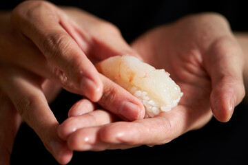 Making raw shrimp sushi by hand