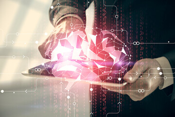 Double exposure of man's hand holding and using a digital device and brain hologram drawing. Data concept.