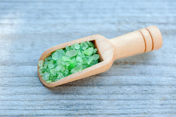 bath salt in a wooden spoon on a wooden background