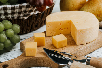 Cheese dish with organic cheeses, fruits, nuts on a wooden background. Delicious cheese snack