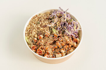 Home delivery container with bowl of chicken, vegetables, sunflower seeds, raisins, white and red quinoa, purple kale, pumpkin seeds, sesame seeds and yakitori sauce