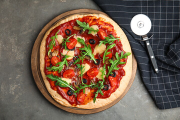 Pita pizza with cheese, olives, tomatoes and arugula on grey table, flat lay