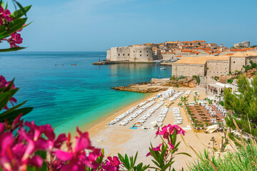 Beautiful view of Banje beach and old town of Dubrovnik with summer flowers in Croatia