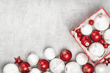 Red and white Christmas baubles in a box flat lay. Merry Christmas and Happy New Year seasons greetings card. Copy space. Festive border