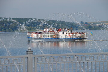 Fountain on a careless pond and a motor ship
