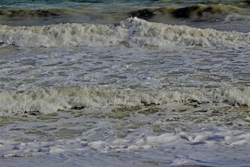 Low angle front on view of rows of waves breaking on or close to the shore