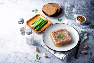 Meat aspic in a plate with mustard
