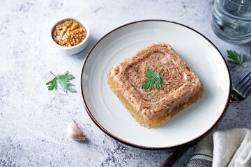Meat aspic in a plate with mustard