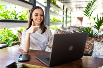 Young pretty woman making video call in cafe