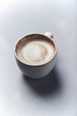 Cup of coffee on paper background. Close up. Copy space.