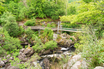 A view of the suspension bridge over the Black River at the Rogie Falls, Ross-Shire, Scotland; UK - 448389682