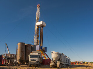Drilling rig with well cementing equipment in the foreground. Infrastructure, communications and...