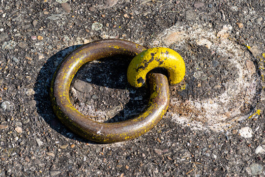 A steel hawser in the shape of a chain eyelet driven into the ground at the quay.