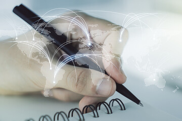 Double exposure of abstract digital world map with connections and man hand writing in notebook on background, research and strategy concept