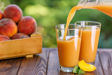fresh peach juice pouring into glass outdoors