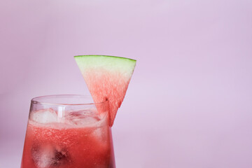 Summer ice watermelon cocktail. Organic soft drink cold snacks on pastel pink wooden background with copy space.
