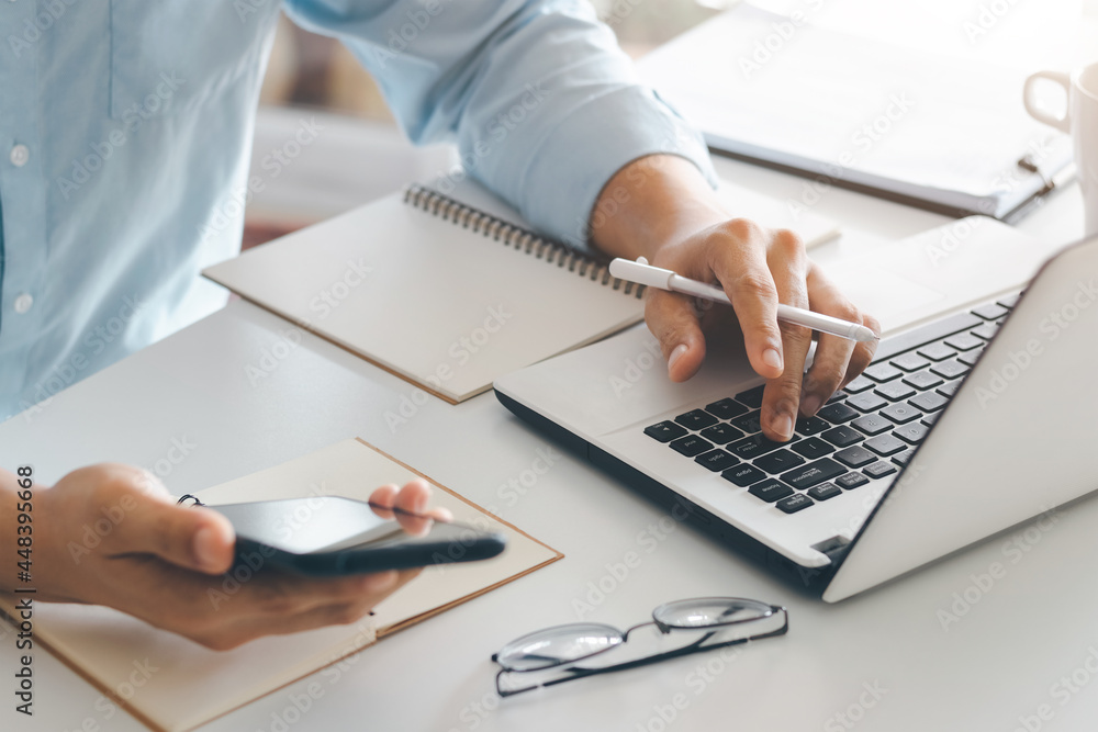 Poster young man using laptop computer and mobile phone when looking for financial information in business,